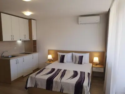 a hotel room with a bed and a kitchen at South Beach Apartment in Nesebar