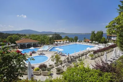 a hotel with a large pool with chairs and umbrellas at Трёхкомнатные роскошные апартаменты у моря в Санта Марина in Sozopol