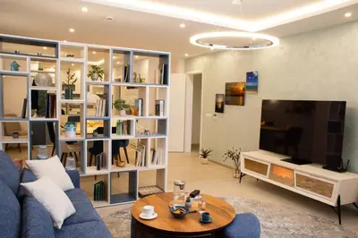 a living room with a blue couch and a tv at Sea Bliss in Burgas City