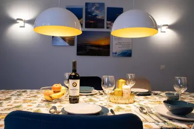 a dining room table with a bottle of wine and glasses at Sea Bliss in Burgas City