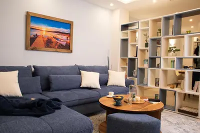 a living room with a blue couch and a table at Sea Bliss in Burgas City