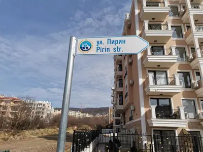 a street sign in front of a tall building at Polarstar Beach Bulgarien Sveti Vlas in Sveti Vlas