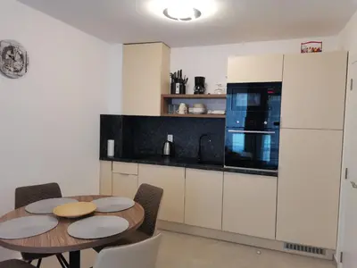 a kitchen with a wooden table and a kitchen with white cabinets at Polarstar Beach Bulgarien Sveti Vlas in Sveti Vlas