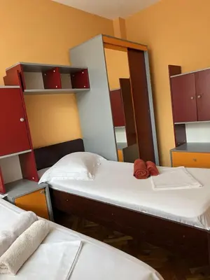 two twin beds in a room with shelves at Apartment Geni in Pomorie