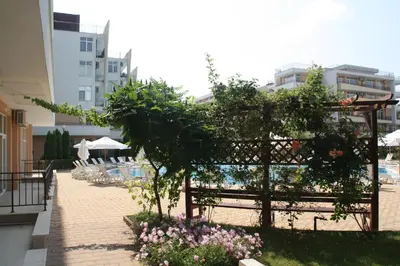 a garden with a fence and some flowers at Grand Kamelia Apartment in Sunny Beach