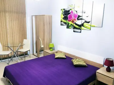 a bedroom with a purple bed in a room at Stamopolu Lux ground floor in Primorsko