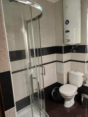 a bathroom with a toilet and a glass shower at Уютно студио в Поморие Мари in Pomorie