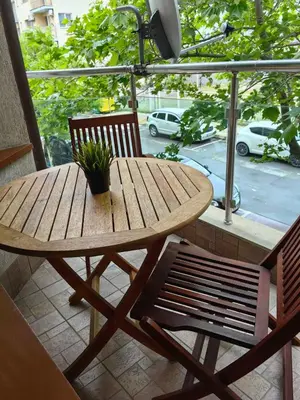 a wooden table and two chairs on a balcony at Уютно студио в Поморие Мари in Pomorie