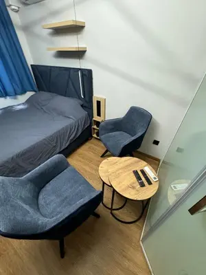 a bedroom with a bed and two chairs and a table at Room de Port in Burgas City