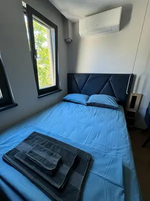a bedroom with a blue bed with a tray on it at Room de Port in Burgas City