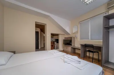 a bedroom with a large white bed and a desk at Citybox - Shipka in Varna City