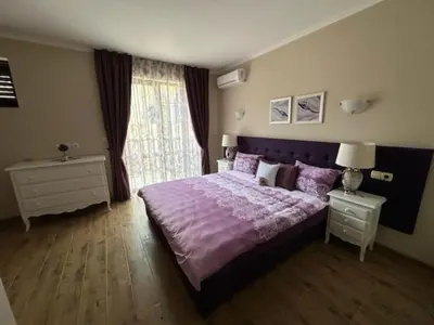 a bedroom with a purple bed and a window at Private Villa in Elenite Resort in Atanasovo