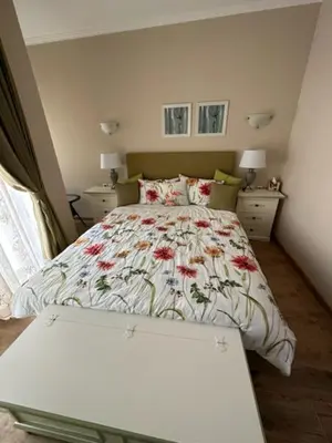 a bedroom with a bed with a floral bedspread at Private Villa in Elenite Resort in Atanasovo