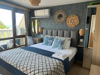 a bedroom with a bed with blue and white pillows at Wavehaven Apartment at South Bay in Varna City