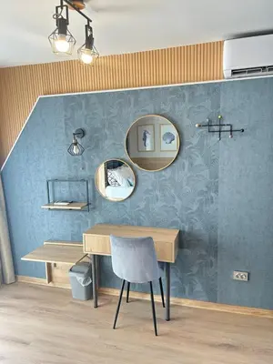 a room with a table and two mirrors and a chair at Wavehaven Apartment at South Bay in Varna City