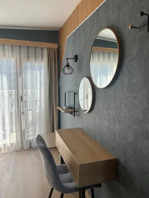 a dining room with a table and a mirror at Wavehaven Apartment at South Bay in Varna City
