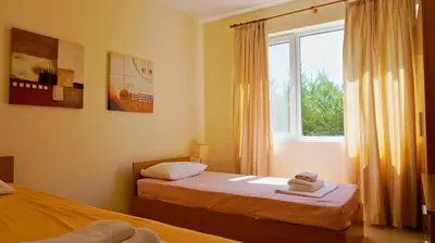 a bedroom with two beds and a window at вила Мариела - villa Mariela in Yunets