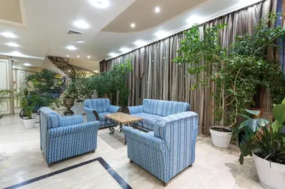 a lobby with blue chairs and a table and plants at Tiara Beach - All Inclusive in Sunny Beach