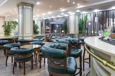 a bar with chairs and tables in a restaurant at Tiara Beach - All Inclusive in Sunny Beach
