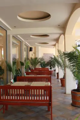 a lobby with a row of benches and plants at Hotel Energy in Kiten