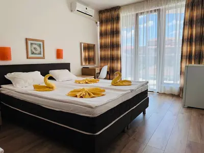 a bedroom with a bed with yellow rubber swans on it at Hotel Energy in Kiten