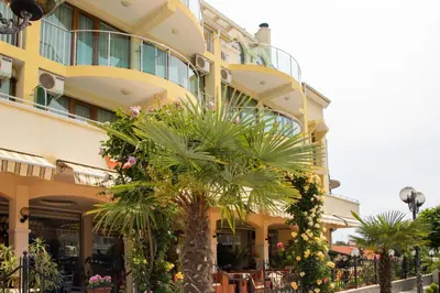 a building with a palm tree in front of it at Hotel Energy in Kiten