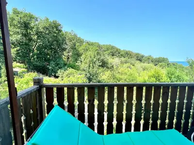 a table on a deck with a mountain in the background at Arkutino Beach in Burgas City