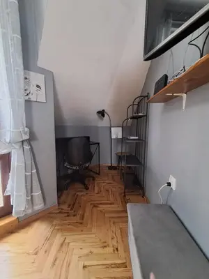a living room with a wooden floor and a bed at Varna city breaks 1 in Varna City