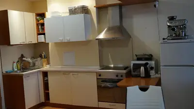 a small kitchen with white cabinets and a refrigerator at Apartmány Bulharsko Sveti Vlas - Garden of Eden in Sveti Vlas
