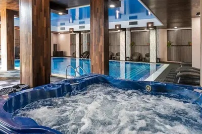 a jacuzzi tub in a hotel with a pool at Apartmány Bulharsko Sveti Vlas - Garden of Eden in Sveti Vlas