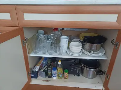 a cupboard filled with dishes and other kitchen items at Rainbow Luci in Sunny Beach