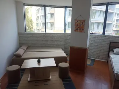 a room with a bed and a table and windows at Rainbow Luci in Sunny Beach