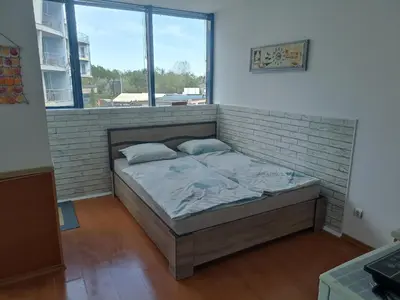 a bed in a room with a brick wall at Rainbow Luci in Sunny Beach