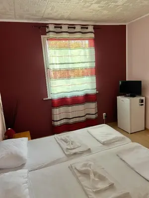 a bedroom with two beds in front of a window at Бунгала Мишел in Varna City
