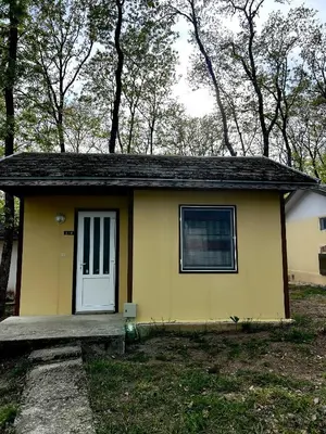 a small yellow house with a white door at Бунгала Мишел in Varna City