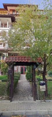 an archway in a park with a bench under it at Studio w kompleksie Ethara-3 in Sveti Vlas