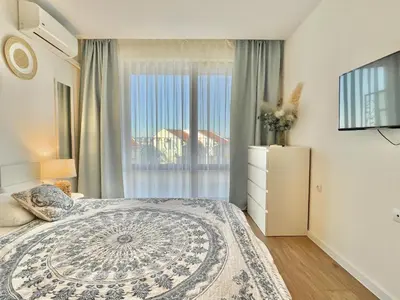 a bedroom with a bed and a large window at Prestige Fort Aparthotel - Private apartment - BSR - 2 in Sveti Vlas