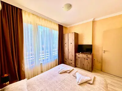 a bedroom with a large bed and a large window at Sea Sun Holiday Apartments Sunny Beach in Sunny Beach