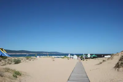 a wooden boardwalk leading to a sandy beach at Menada Diamant Apartments in Sunny Beach