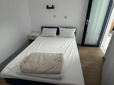 a white bed with a blanket on it in a room at Apartment Bela in Burgas City