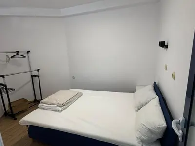 a small bedroom with a bed with white sheets at Apartment Bela in Burgas City