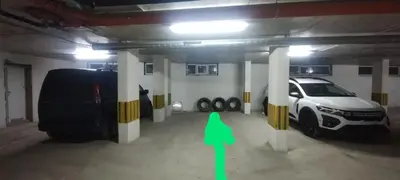 a car parked in a parking garage with a green arrow at Apartment Bela in Burgas City