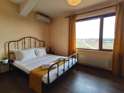 a bedroom with a bed with a large window at Casa Soleada in Bliznatsi