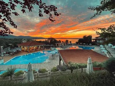 a view of a pool with a sunset in the background at Studio Sea Breeze Veranda in Santa Marina in Sozopol