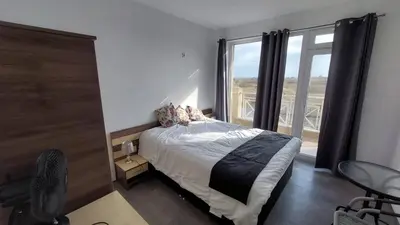 a bedroom with a bed and a large window at Sunny Day 6 , Sunny beach, 3-Стаен апартамент in Tŭnkovo