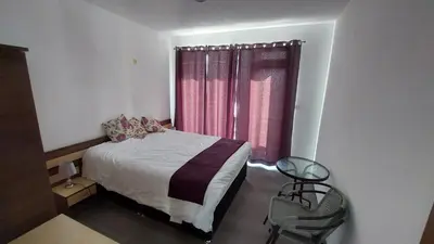 a bedroom with a bed and a window with pink curtains at Sunny Day 6 , Sunny beach, 3-Стаен апартамент in Tŭnkovo