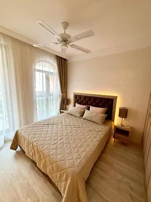 a bedroom with a large bed with a ceiling fan at VIP Harmony Suites 20 SVETY VLAS in Sveti Vlas
