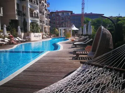 a swimming pool with chaise lounges and lounge chairs at VIP Harmony Suites 20 SVETY VLAS in Sveti Vlas