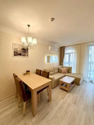 a living room with a table and a couch at VIP Harmony Suites 20 SVETY VLAS in Sveti Vlas