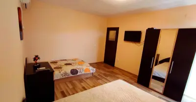 a room with a bedroom with a bed and a dresser at Апартамент Сиракови Черноморец in Chernomorets